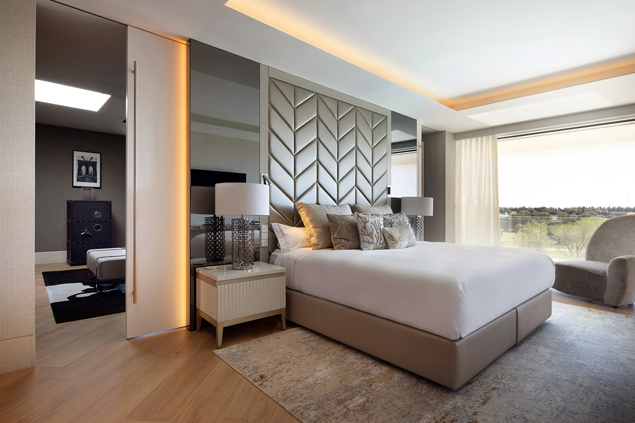 Dormitorio de lujo con cabecero tapizado fabricado a medida en tonos blanco y marrón.