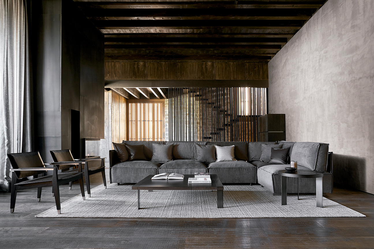 Salón moderno gris y negro con sofá modular vanguardista y sillones de piel diseñado por Ramón Esteve.