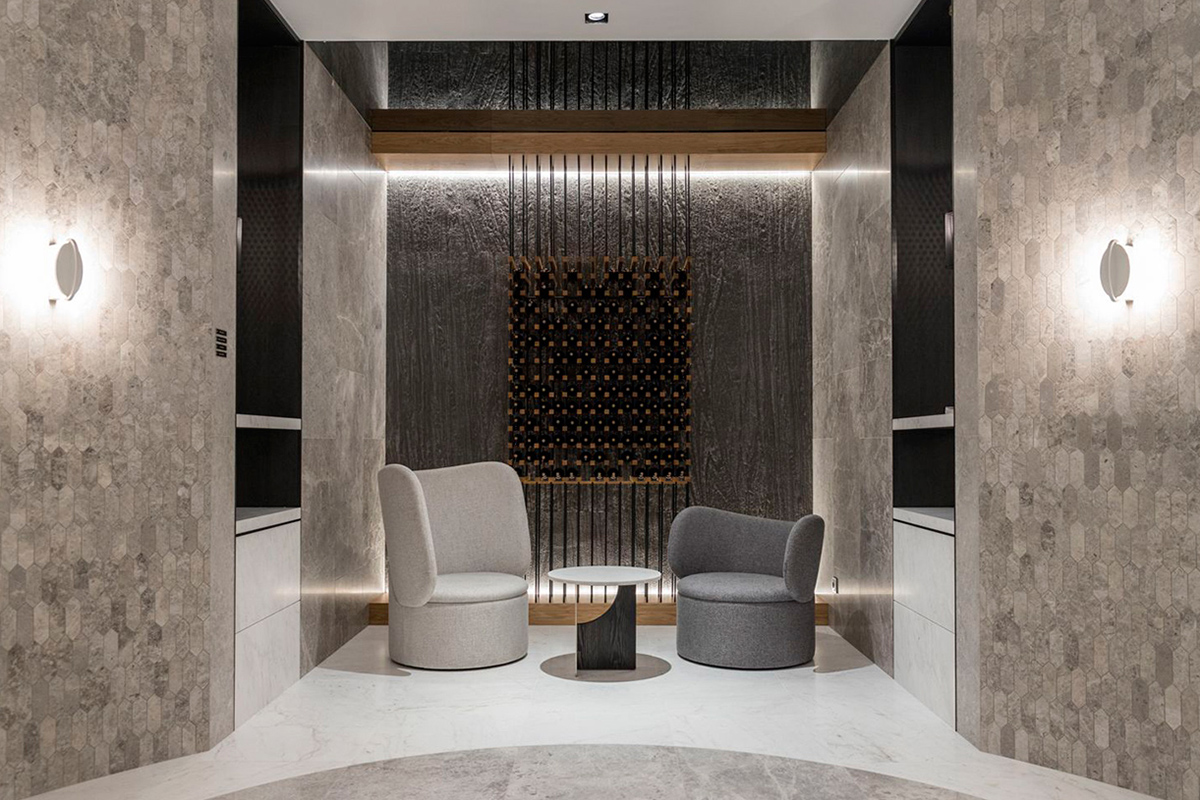 An original wine cabinet with modern Cobra armchairs, a contemporary space that evokes luxury and sophistication.