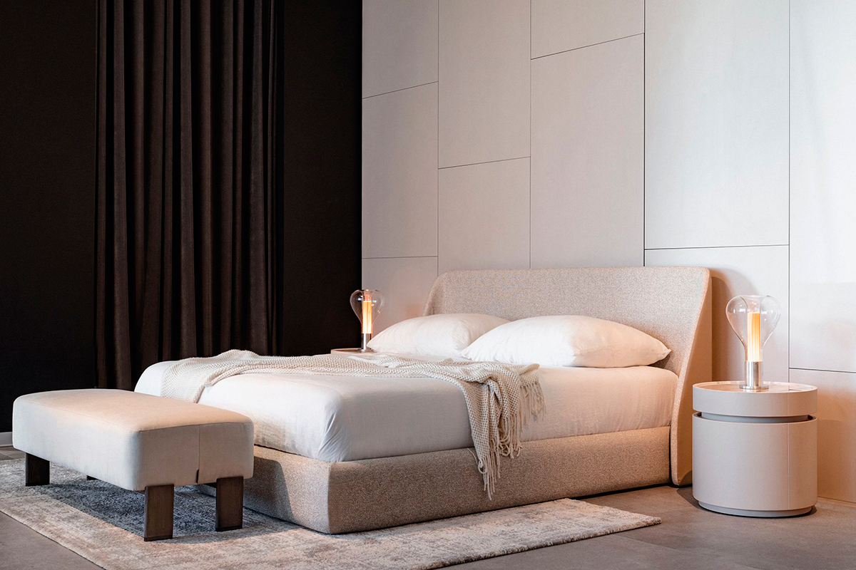 Modern, high-end bedroom with Atlas bed and upholstered headboard, Nora round bedside tables and Jude bench.